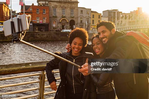 tourists taking selfies on vacation in dublin ireland - hapenny bridge stock pictures, royalty-free photos & images