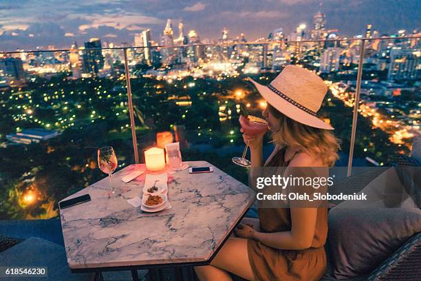 woman drinking in rooftop bar in bangkok - thailand skyline stock pictures, royalty-free photos & images