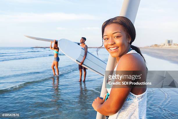 lächelnder teenie-surfer bereitet sich aufs surfen vor - golfküste stock-fotos und bilder