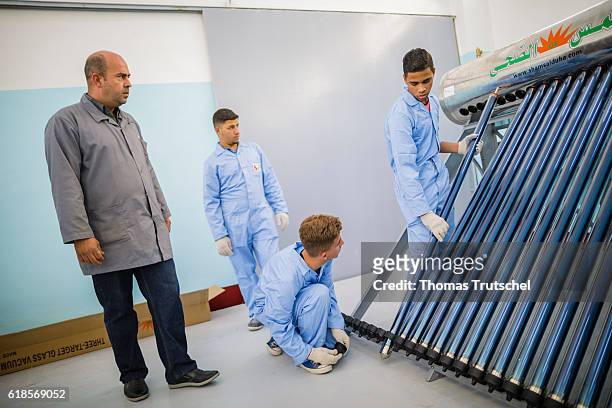 Al Rusaifeh, Jordan Three apprentices install a hot water system at the vocational training center VTC, an instructor observes them on October 05,...