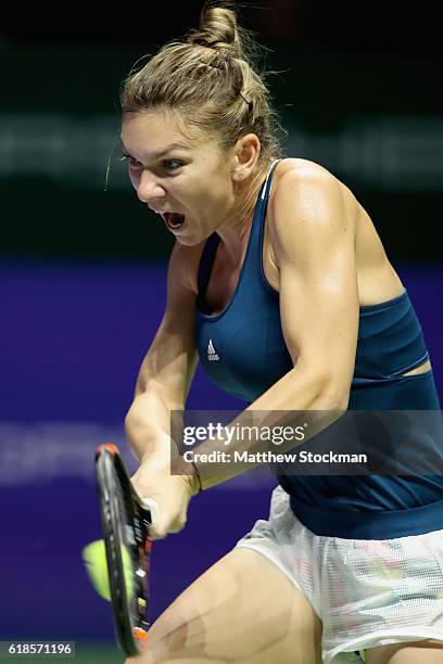 Simona Halep of Romania plays a backhand in her singles match against Dominika Cibulkova of Slovakia during day 5 of the BNP Paribas WTA Finals...