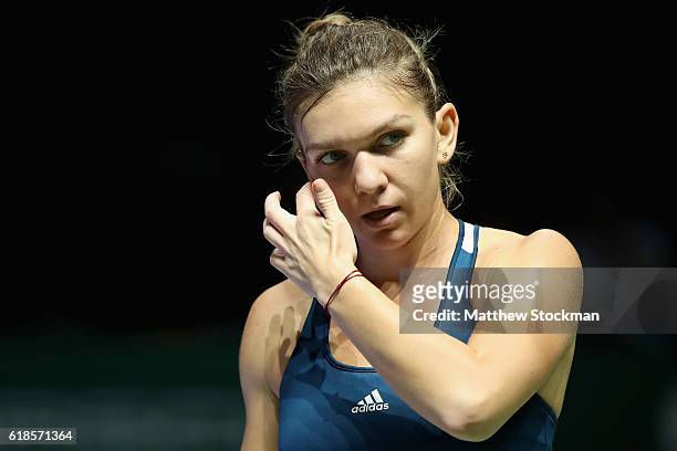 Simona Halep of Romania reacts in her singles match against Dominika Cibulkova of Slovakia during day 5 of the BNP Paribas WTA Finals Singapore at...
