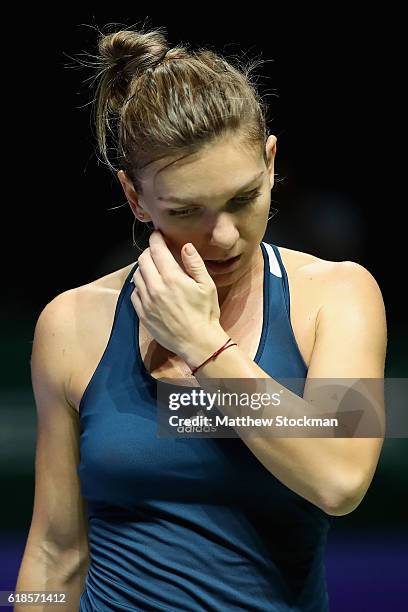 Simona Halep of Romania reacts in her singles match against Dominika Cibulkova of Slovakia during day 5 of the BNP Paribas WTA Finals Singapore at...