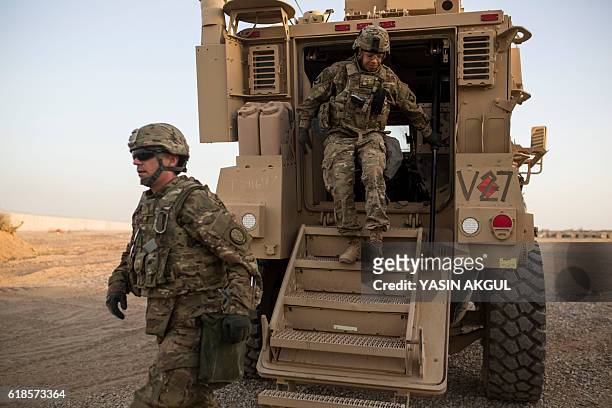 Photo taken on October 20, 2016 shows US soldiers getting out of a military vehicle at the Qayyarah military base during the ongoing operation to...