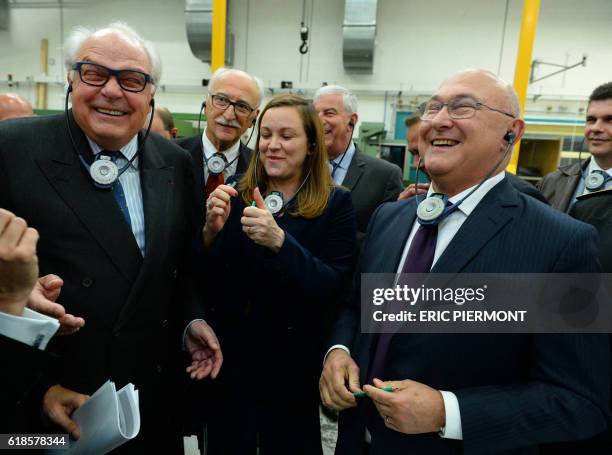 French Economy and Finance Minister Michel Sapin smiles, flanked by Digital Sector and Innovation Junior Minister Axelle Lemaire and Bic Chairman...