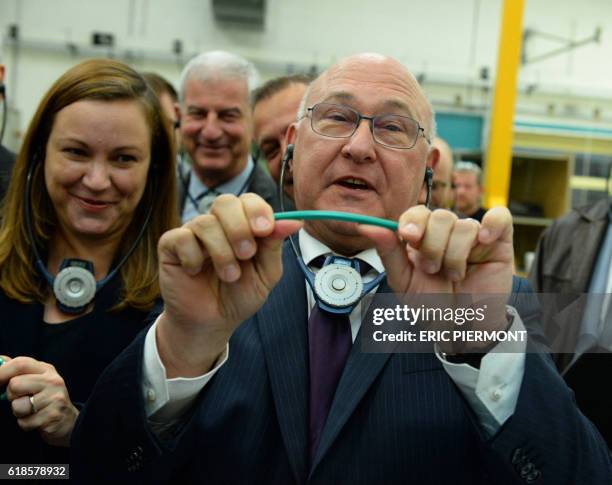 French Economy and Finance Minister Michel Sapin holds a Bic pencil, flanked by Digital Sector and Innovation Junior Minister Axelle Lemaire , as he...