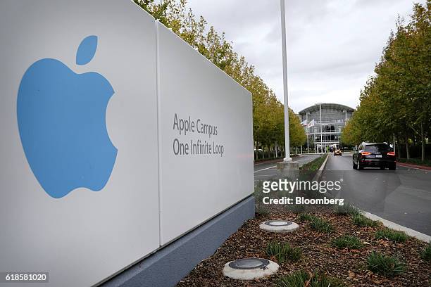 Vehicles drive past signage ahead of an Apple Inc. Event at the company's headquarters in Cupertino, California, U.S., on Thursday, Oct. 27, 2016....