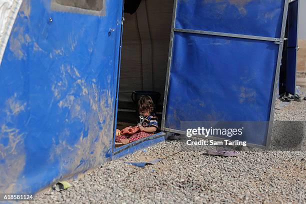 Young child sits by the door of her tent at a newly opened camp for people who have been forced to flee their homes due to the current offensive on...