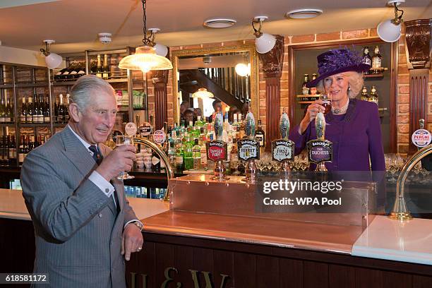 Britain's Camilla, Duchess of Cornwall and Prince Charles, Prince of Wales drink a half pint of "The Duchess" ale inside the Duchess of Cornwall pub...