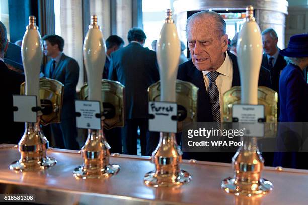 Britain's Prince Philip, Duke of Edinburgh looks at beer taps inside the Duchess of Cornwall pub on October 27, 2016 in Poundbury, England. The Queen...