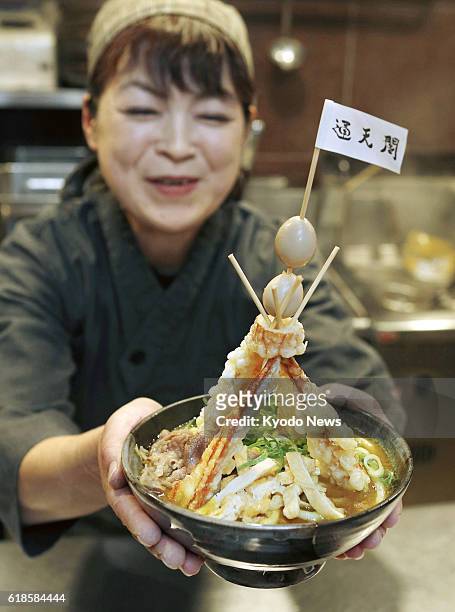 Woman holds a bowl of "Tower Curry Udon" noodles at a restaurant inside Shin-Imamiya Station of Nankai Electric Railway Co. In Osaka on Oct. 27 ahead...