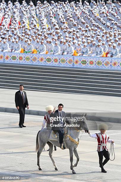 President of Turkmenistan Gurbanguly Berdimuhamedow greets people onto the horse during the official parade held for the 25th anniversary of...