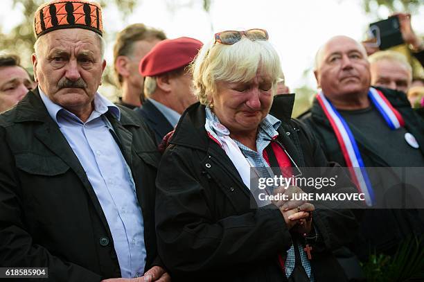 Woman cries during a ceremony marking the beginning of the burial of remains of some 800 people killed by communist forces after World War II at the...