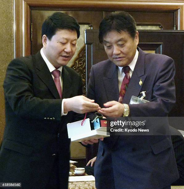 Japan - Liu Zhiwei , a member of the Chinese Communist Party's Nanjing City Standing Committee, and Nagoya Mayor Takashi Kawamura exchange gifts...