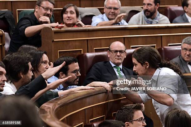 Leader of anti-austerity political party Podemos, Pablo Iglesias speaks with his parliamentary group before leaving the chamber to protest that the...