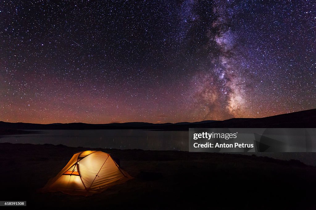 Orange tent in the mountains at night