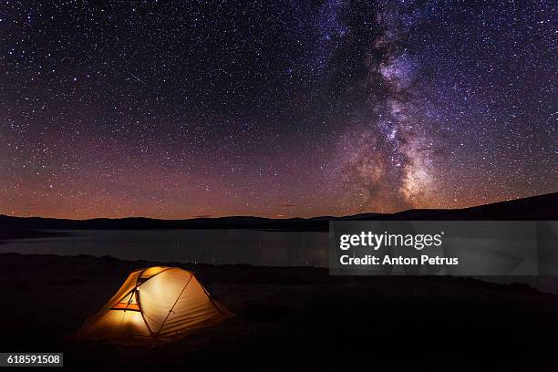 orange tent in the mountains at night - base camp stock pictures, royalty-free photos & images