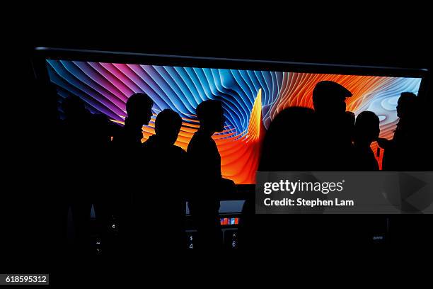 Guests and members of the media are seen in front of a photo display of a MacBook laptop computer during a product launch event on October 27, 2016...