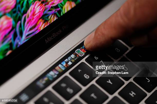 An Apple employee points to the Touch Bar on a new Apple MacBook Pro laptop during a product launch event on October 27, 2016 in Cupertino,...