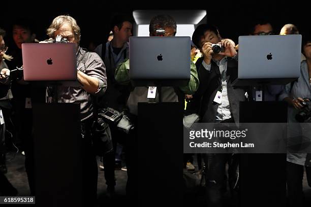 Members of the media photograph the new Apple MacBook Pro laptop during a product launch event on October 27, 2016 in Cupertino, California. Apple...