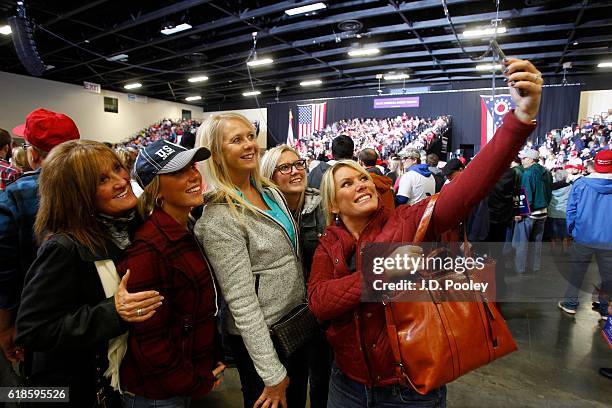 Supporters of Republican presidential nominee Donald Trump take photos during a campaign event at the SeaGate Convention Centre on October 27, 2016...