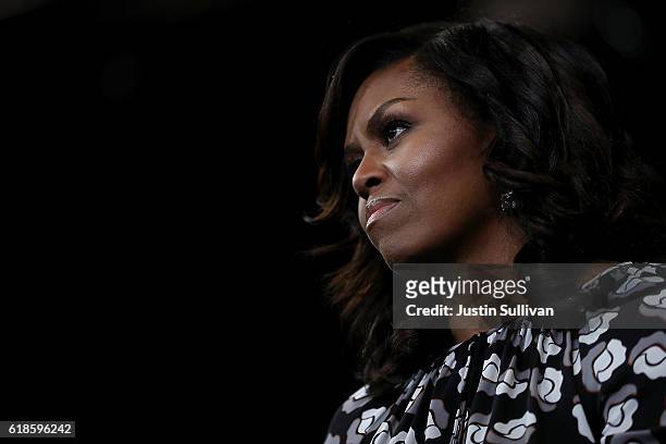 First Lady Michelle Obama looks on as democratic presidential nominee former Secretary of State Hillary Clinton speaks during a campaign rally at...