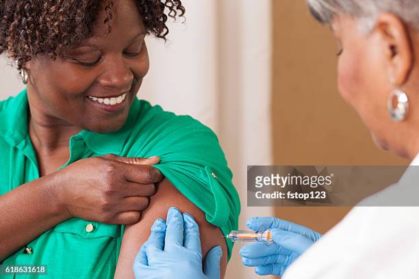 医師または看護師は、診療所で患者にインフルエンザワクチンを与えます。 - インフルエンザワクチン ストックフォトと画像