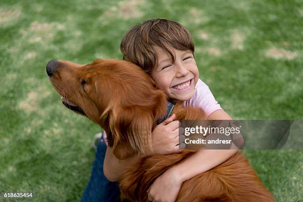 glücklicher junge mit einem schönen hund - cute animals cuddling stock-fotos und bilder