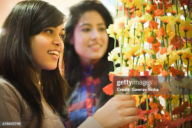 garotas comprando parede floral pendurada em loja de decoração antes do festival. - fake of indian girls - fotografias e filmes do acervo