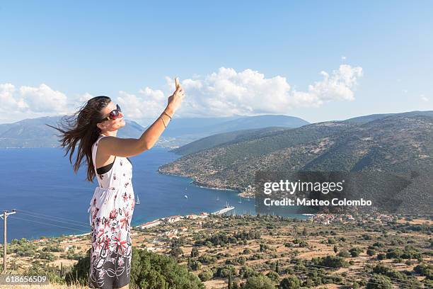 woman doing a selfie on lookout in summer - kefalonia fotografías e imágenes de stock