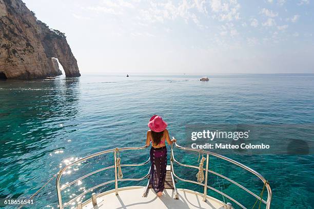 woman on prow of sailboat in the blue sea, greece - blue sailboat stock pictures, royalty-free photos & images