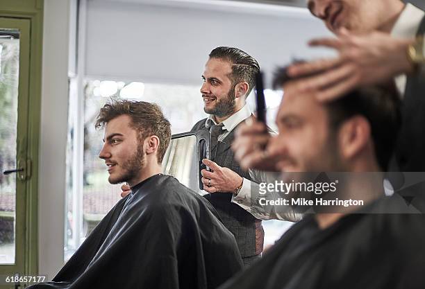 barber showing client his haircut - cabeleireiro imagens e fotografias de stock