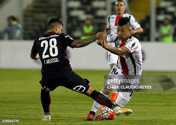 Chilean Palestino's footballer Leonardo Valencia vies for the ball with Franco Mussis of Argentina's San Lorenzo during their Copa Sudamericana...