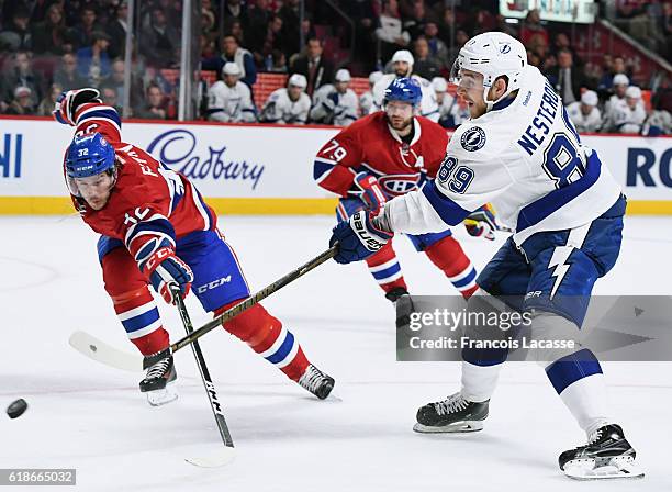 Nikita Nesterov of the Tampa Bay Lightning takes a shot against Brian Flynn the Montreal Canadiens in the NHL game at the Bell Centre on October 27,...