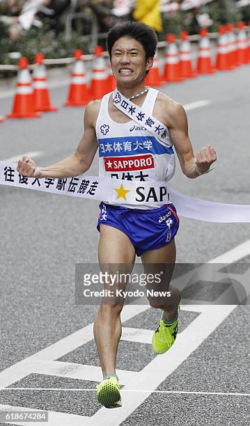 Japan - Nippon Sport Science University anchor Yuichi Taninaga crosses the finishing line in Tokyo's Otemachi business district on Jan. 3, 2013....