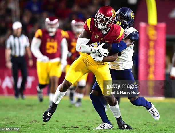 Wide receiver Darreus Rogers of the USC Trojans is wrapped up by cornerback Marloshawn Franklin Jr. #18 of the California Golden Bears after his...