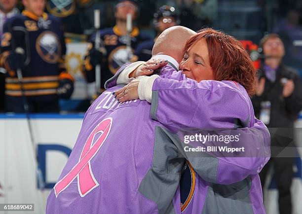 Roswell Park Cancer Institute patients Dan Zotara and Colleen Williams embrace during ceremonies on Hockey Fights Cancer Night prior to the NHL game...