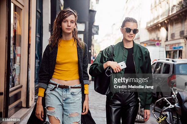 Models wear and orange top and green bomber jacket on September 27, 2016 in Paris, France.