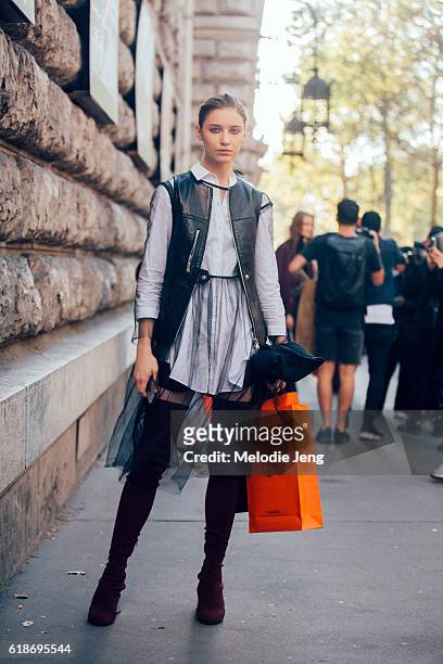 Russian model Sofia Tesmenitskaya wears leather vest, a shirtdress, and thigh-high boot safter the Hermes show on October 03, 2016 in Paris, France.