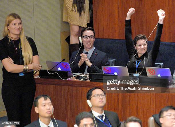 Members of the International Campaign to Abolish Nuclear Weapons celebrate after the resolution is passed during the United Nations First Committee,...