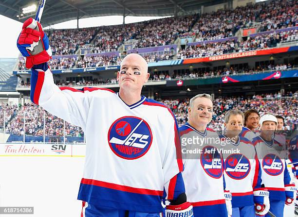 Jim Kyte of the Winnipeg Jets alumni team waves to the crowd during team introductions for the 2016 Tim Hortons NHL Heritage Classic Alumni Game to...