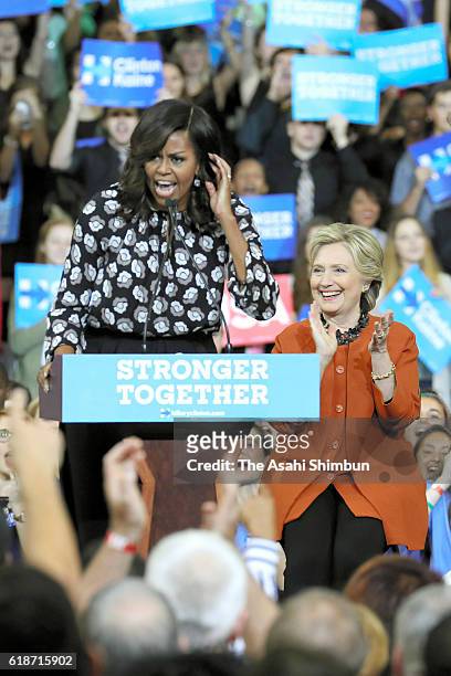 Democratic presidential nominee former Secretary of State Hillary Clinton looks on as First Lady Michelle Obama speaks during a campaign rally at...