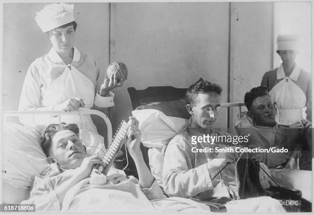 Three wounded soldiers knit from a hospital bed at Walter Reed Hospital, Washington, District of Columbia, 1917. Image courtesy National Archives. .