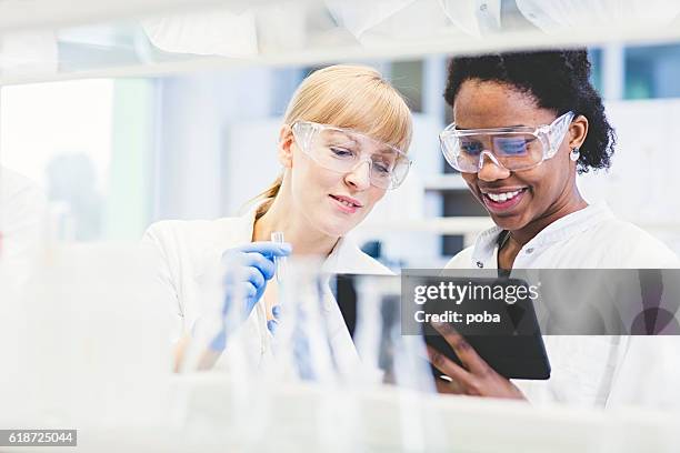 scientists working together in lab - laboratory stockfoto's en -beelden