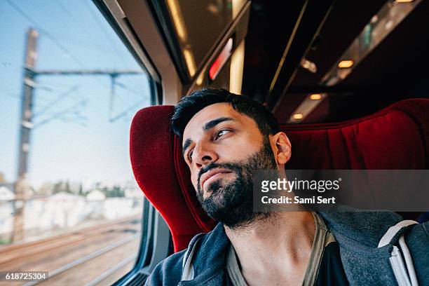 young man traveling in train - lost in thought - sad commuter stockfoto's en -beelden