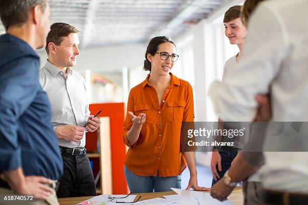 young professionals meeting around a table - office worker chatting bildbanksfoton och bilder