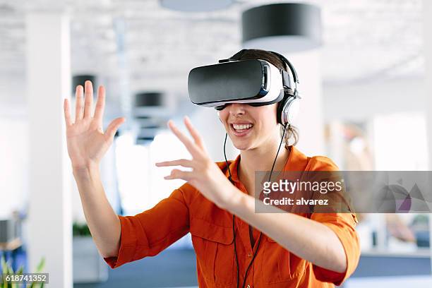 woman using virtual reality simulator headset - vr stock pictures, royalty-free photos & images