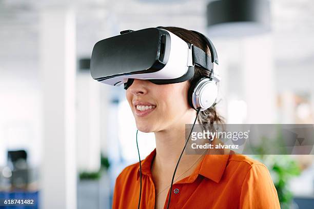 frau mit virtual-reality-brille im büro - vr goggles woman stock-fotos und bilder