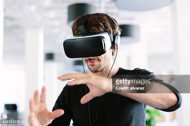 man using virtual reality simulator headset - bril stockfoto's en -beelden