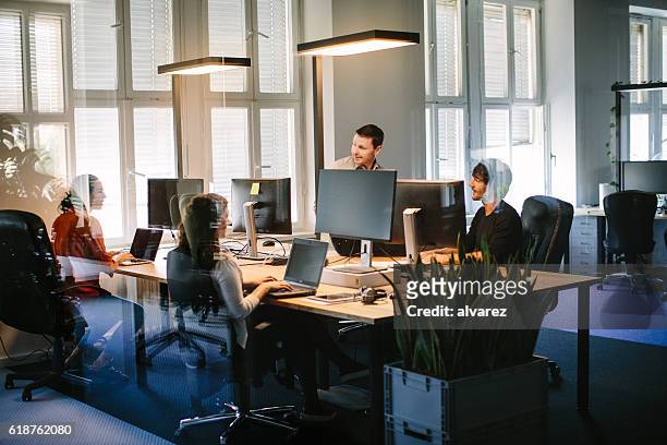 geschäftsleute, die in modernen büroräumen arbeiten - office partition stock-fotos und bilder